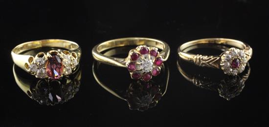 Two early 20th century 18ct gold and ruby cluster dress rings and a similar garnet and diamond ring, sizes O & L(2).